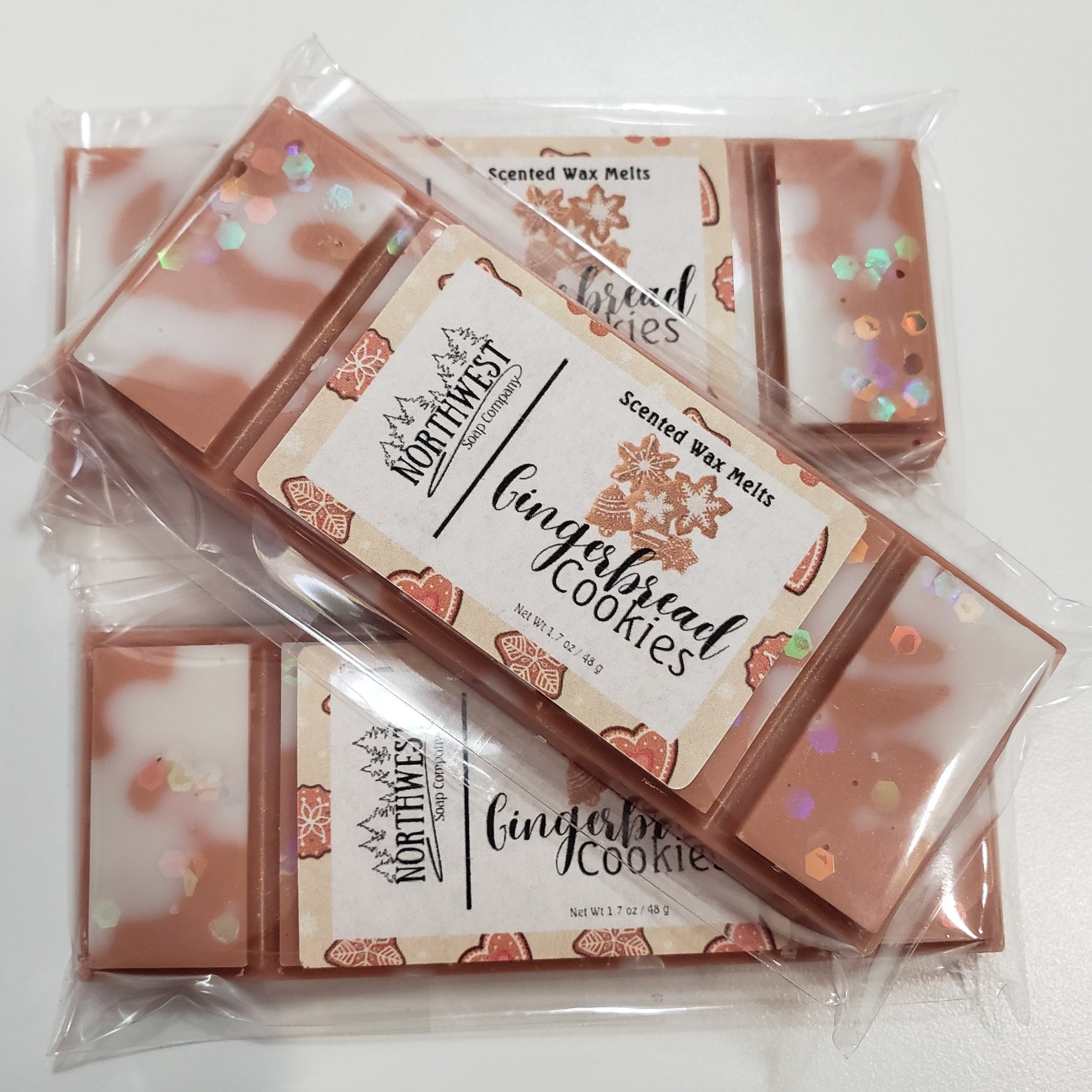 3 Gingerbread Cookie wax melts packaged in their recylable 5 PP wrappers.  Shaped like a candy bar in a ginerbread brown wax  with white drizzle and eco glitter.