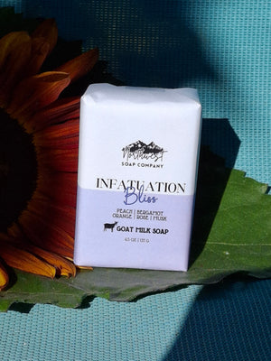 Bar of soap pictured with sunflower on blue background