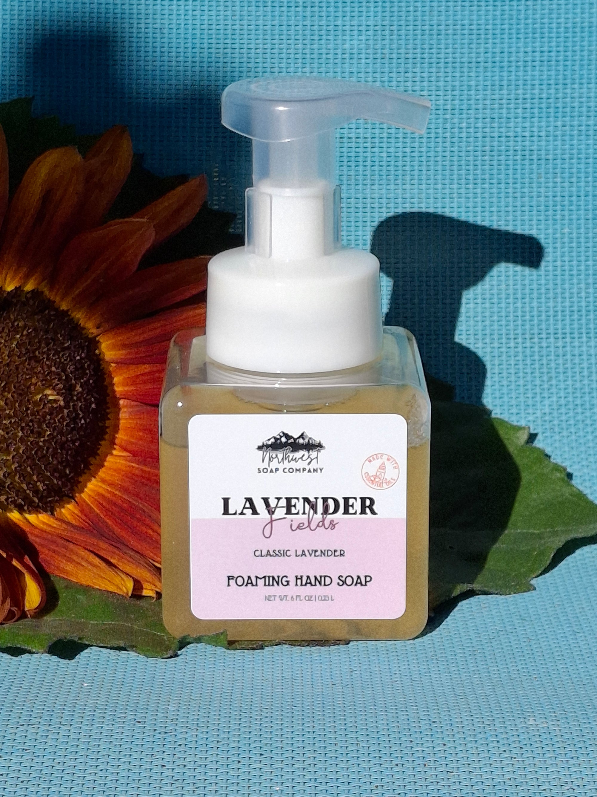 foaming hand soap pictured with sunflower on blue background