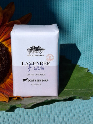 Bar of soap pictured with a sunflower on blue background