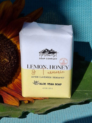 Bar of soap pictured with a sunflower on blue background
