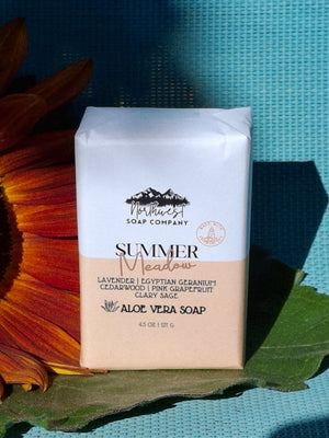 Bar of soap pictured with a sunflower on blue background