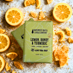 Two bars of Northwest Soap & Candle Company soap with lemon slices on a textured surface