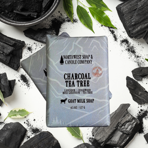two bars of charcoal and tea tree soap on a white background with bamboo charcoal
