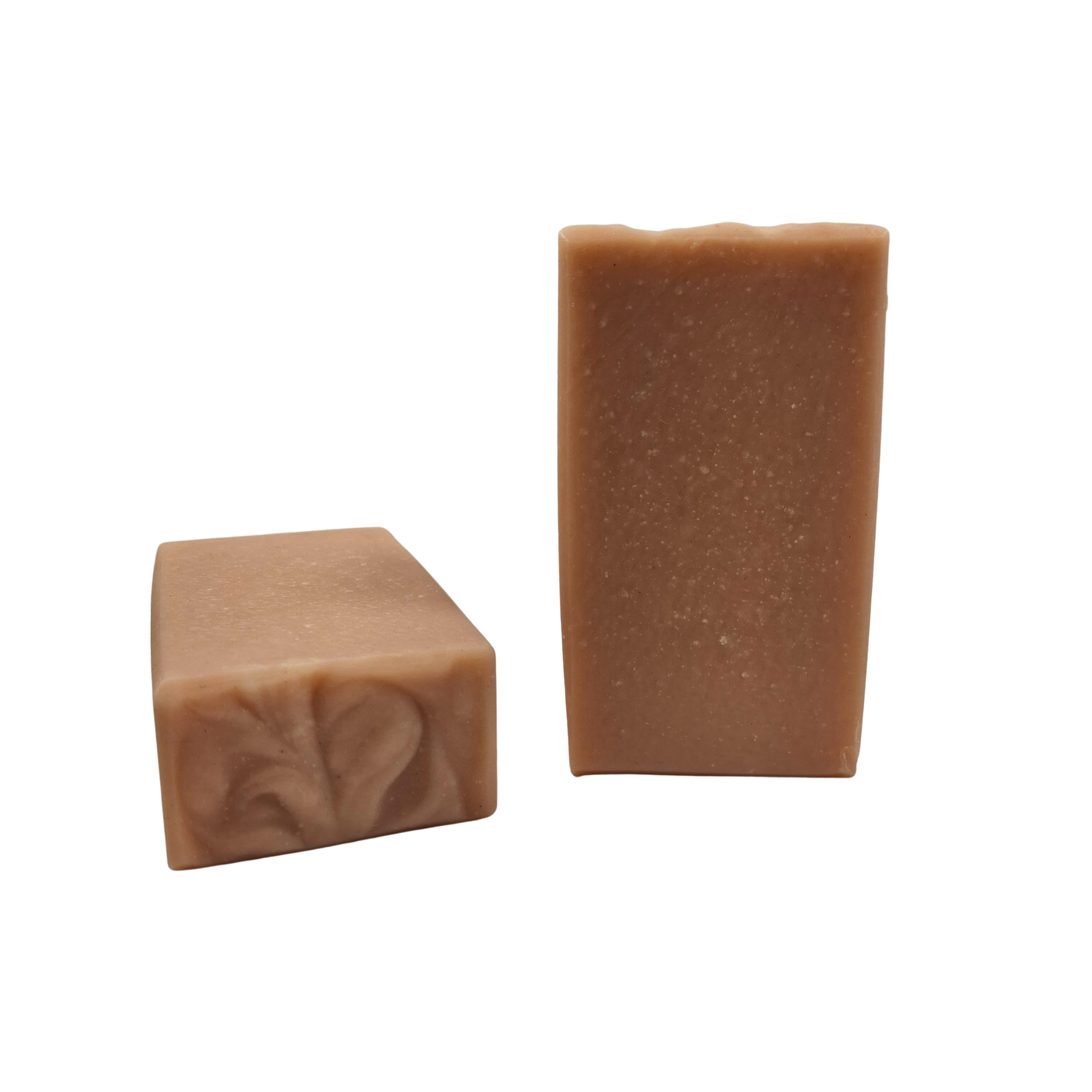 Two bars of Coconut Rose soap that are pale pink in color.