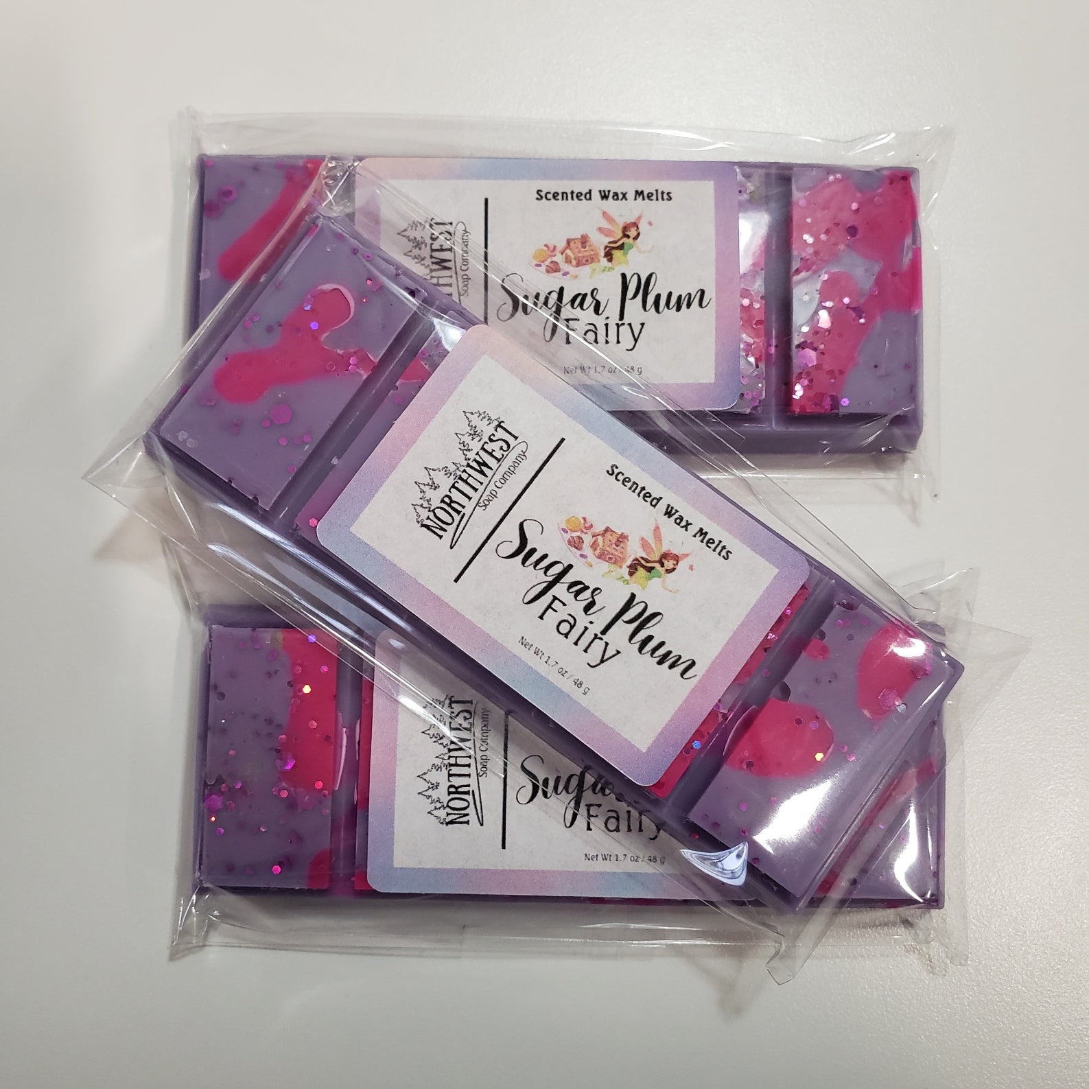 3 bars of Sugar Plum Fairy wax melt bars packaged in recyclable  PP wrappers. Colored in Purple with hot pink drizzle and eco glitter.