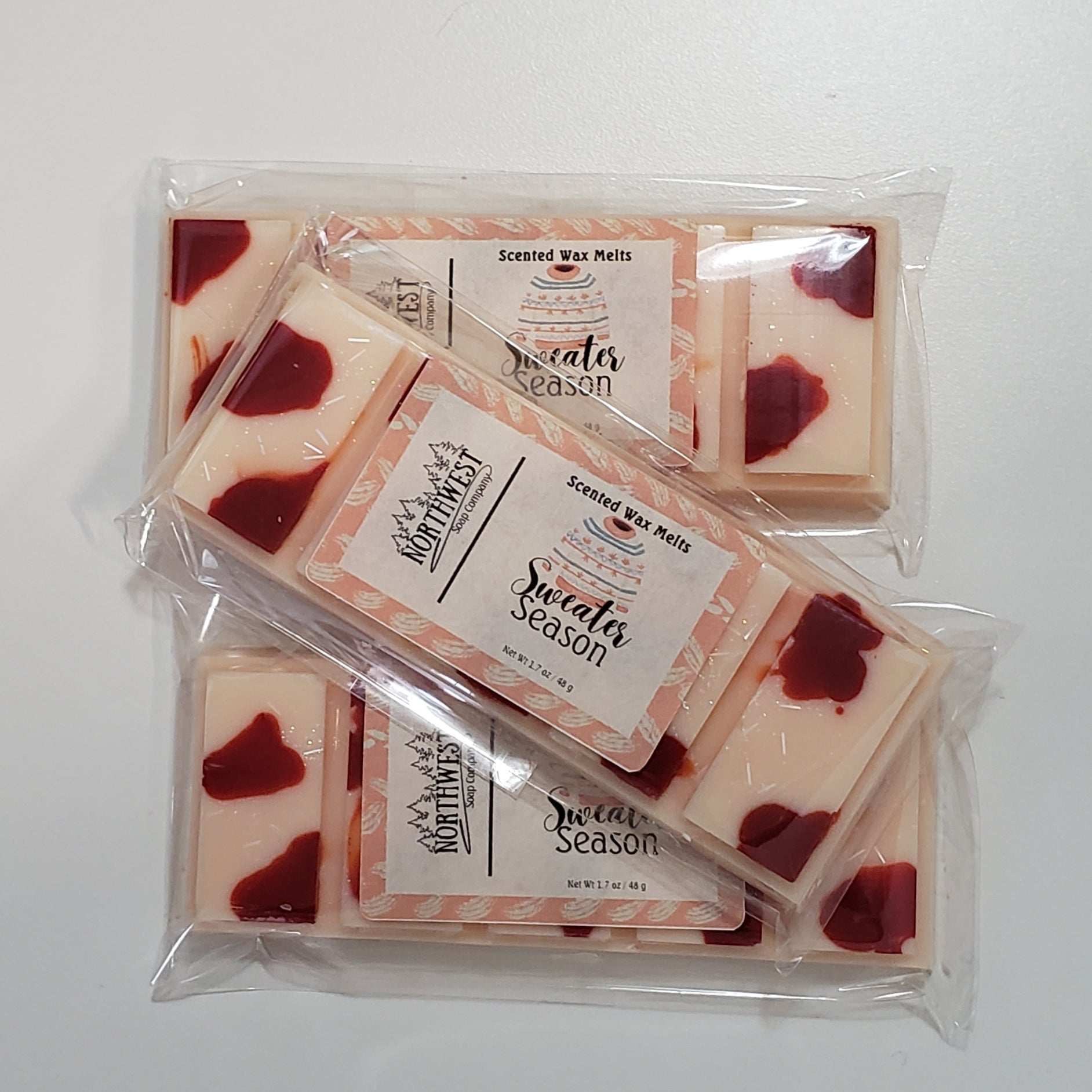 3 Sweater Season Wax melts in their recyclable 5 PP wrappers.  Light coral wax with dark coral splotches and eco glitter.